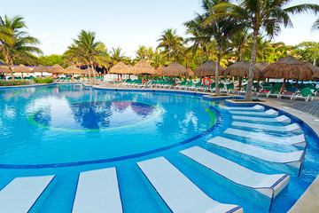 Tropical swimming pool with sunbeds in Mexico
