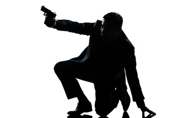 silhouette man kneeling aiming gun