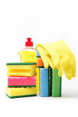 Detergent bottle, rubber gloves and cleaning sponge on a white b