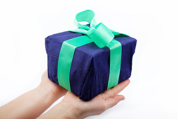 Gift pack in the women's hand on a white background.