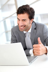 Portrait of cheerful businessman showng thumb up