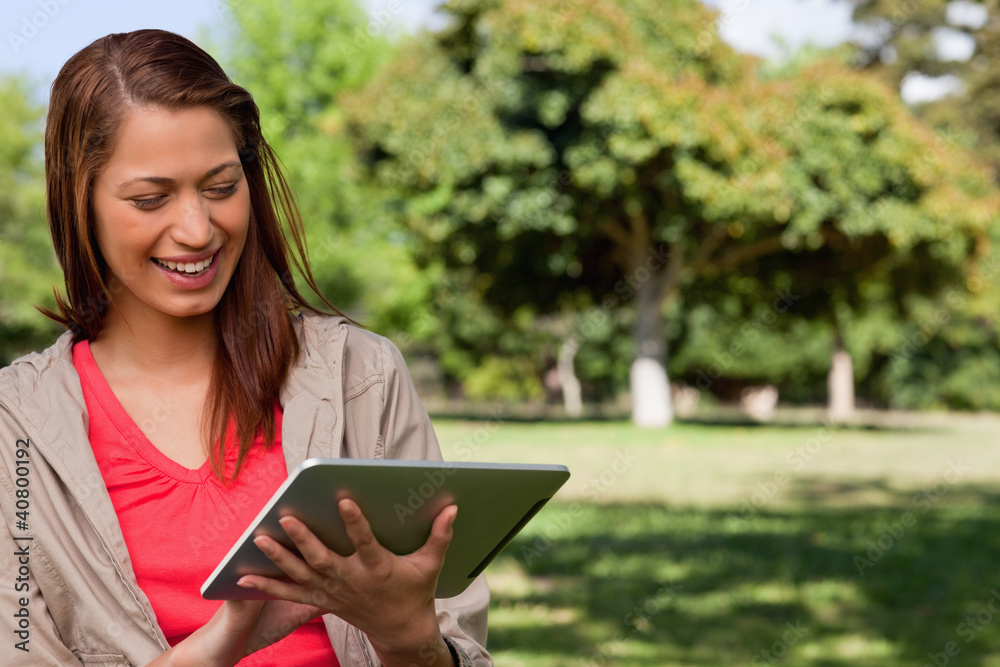 Poster young woman smiling enthusiastically while using a tablet