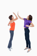 Obraz premium Teenagers jumping while giving each other a high-five