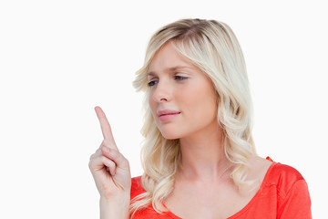 Attractive young woman raising her finger in the air