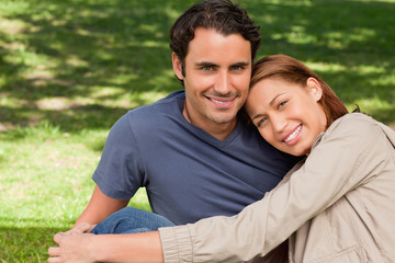 Obraz premium Man smiling as his friend rests his rests her head on his should