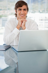 Smiling young businessman resting his head on his hands