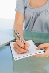 Fototapeta premium Close up of a woman writing on a notepad