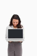 Woman standing while showing a laptop screen