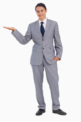 Smiling man in suit presenting with the hand