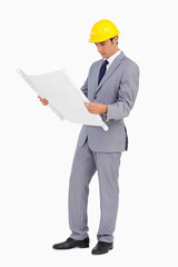 Man in a suit with safety helmet watching plans
