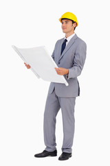 Good-looking man in a suit with safety helmet and plans