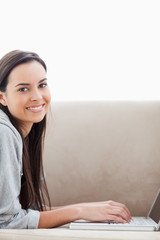 Close up shot of a woman lying on her couch as she looks into th