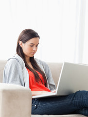 Woman using her laptop as she sits on the couch