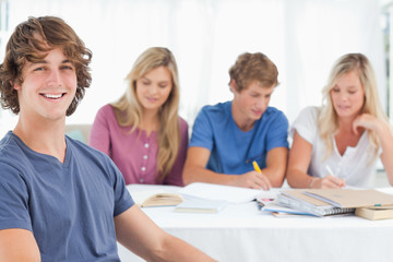 Close up of a smiling man sitting in front of his friends
