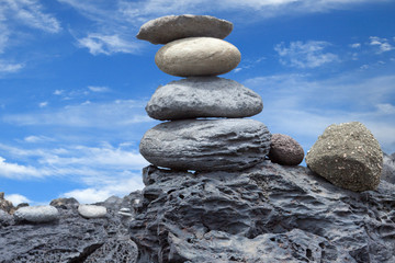 pyramide de galets sur fond de ciel bleu