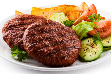 Grilled beefsteaks, baked potatoes and vegetable salad