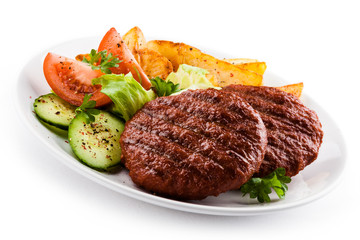 Grilled beefsteaks, baked potatoes and vegetable salad