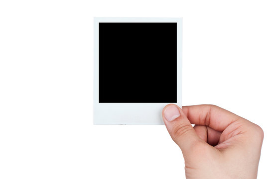 young male hand holding instant photo against white background