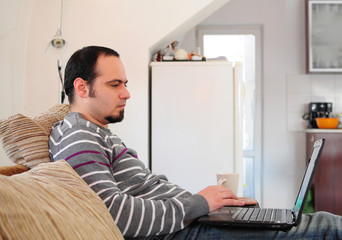 Young man with laptop at home