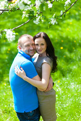 Young Couple in love in the spring blossoming apple orchard