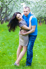 Fototapeta premium Young Couple in love in the spring blossoming apple orchard