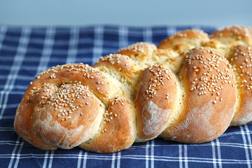 Artisan braided loaf with sesame seeds on a table