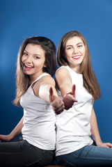 Fototapeta na wymiar Portrait of a beautiful happy smiling young women with thumbs up