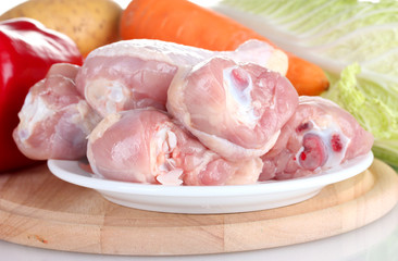 Fresh vegetables with raw chicken drumsticks