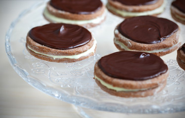 Chocolate biscuits with chocolate ganache on a glass cookie tray