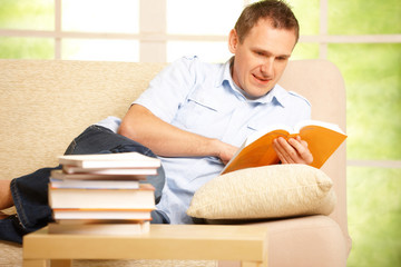 Man reading book in home