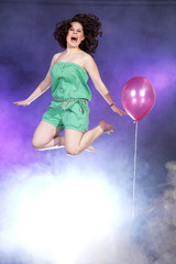 Frau springt vor Freude hoch mit Luftballon Porträt