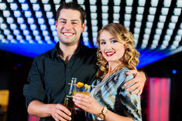 People with cocktails in bar or club