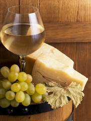 White wine in fine glass with cheese and grape
