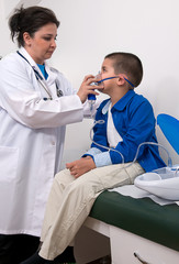 Female doctor applying oxygen treatment on asthma child.