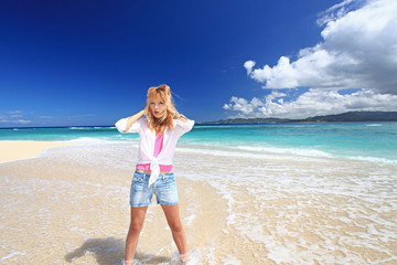 水納島の真っ白いビーチで遊ぶ笑顔の女性
