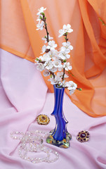 Apricot flowers in a vase against a background of pink and orang