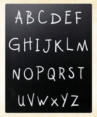 Complete english alphabet handwritten with white chalk on a blac