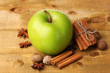 Cinnamon sticks, green apple, nutmeg,and anise on wooden table