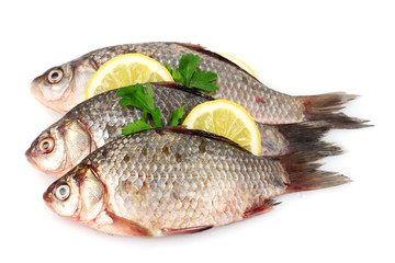 Fresh fishes with lemon, parsley and spice isolated on white