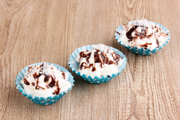 Creamy cupcakes on wooden background