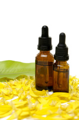 bottles of essential oil and yellow flower peals