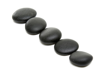 Black massage stones on white