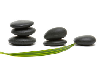 arrangement Balanced black zen pebbles with green leaf