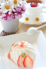 White Milk jelly with strawberry on table with flower
