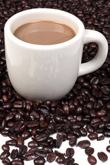 Mug full of hot coffee and beans