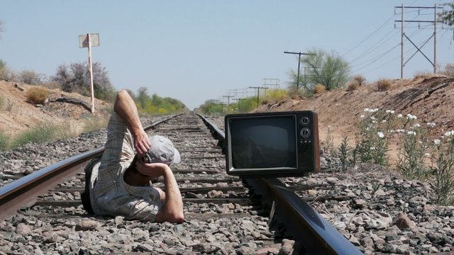 Squatting on the Railway with an Old, Retro TV