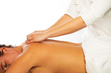 klassische Rückenmassage einer Frau durch Physiotherapeutin vor weissem Hintergrund horizontal