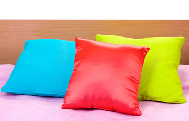 bright pillows on bed on white background