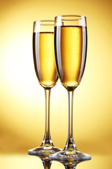 glasses of champagne on yellow background