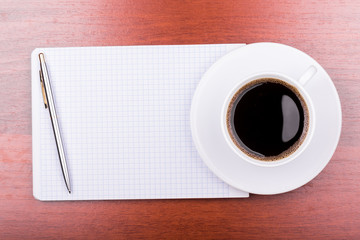 Cup of coffee on notepad